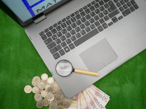 laptop with cash and magnifying glass